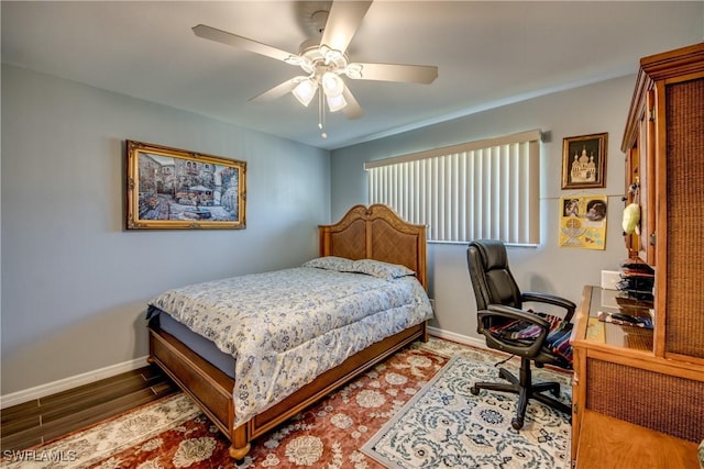 bedroom with ceiling fan, baseboards, and wood finished floors