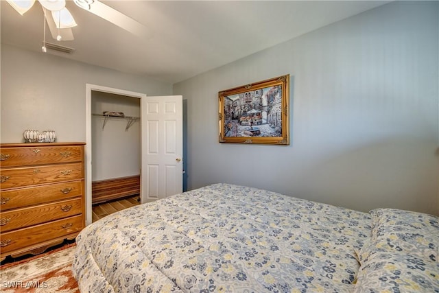 bedroom featuring a closet, visible vents, ceiling fan, and wood finished floors