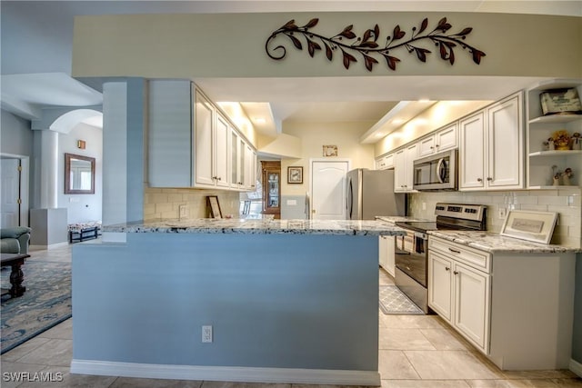 kitchen with light tile patterned floors, a peninsula, light stone countertops, stainless steel appliances, and open shelves