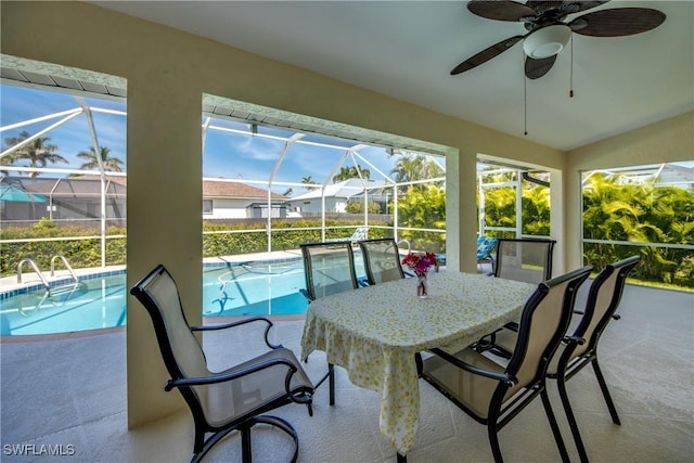 sunroom / solarium with ceiling fan and a swimming pool