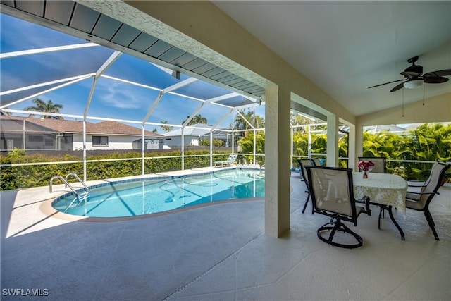 pool featuring glass enclosure, a ceiling fan, and a patio