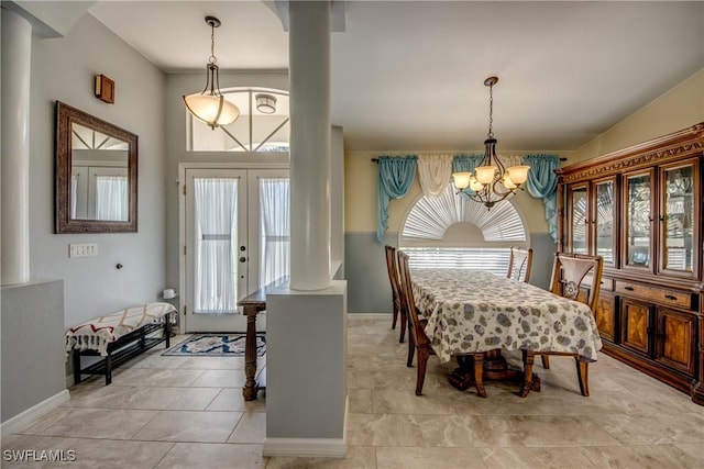 dining room with ornate columns, baseboards, and a notable chandelier