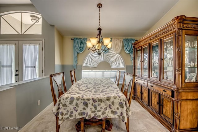 dining room featuring a chandelier, vaulted ceiling, and light tile patterned floors