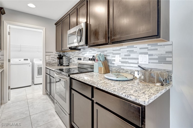 kitchen featuring washer and clothes dryer, stainless steel appliances, light tile patterned floors, decorative backsplash, and dark brown cabinets