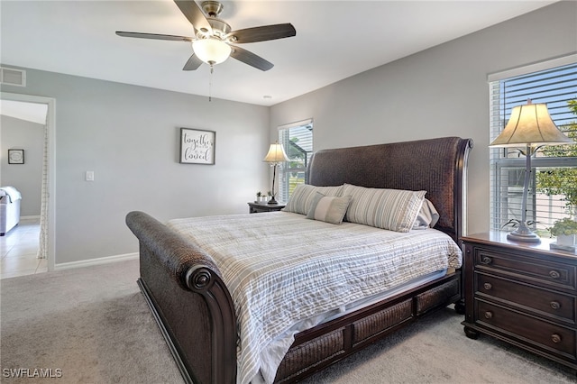 bedroom with light carpet, visible vents, ceiling fan, and baseboards