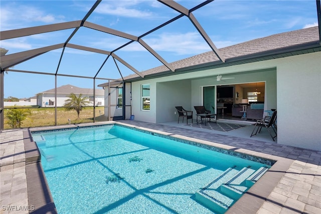 pool with ceiling fan, glass enclosure, and a patio