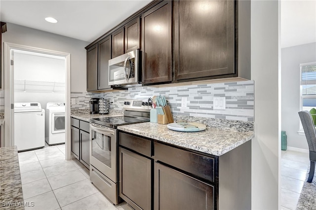 kitchen with washer and dryer, tasteful backsplash, appliances with stainless steel finishes, light tile patterned flooring, and dark brown cabinets