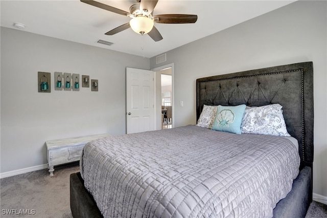 carpeted bedroom with visible vents, baseboards, and a ceiling fan