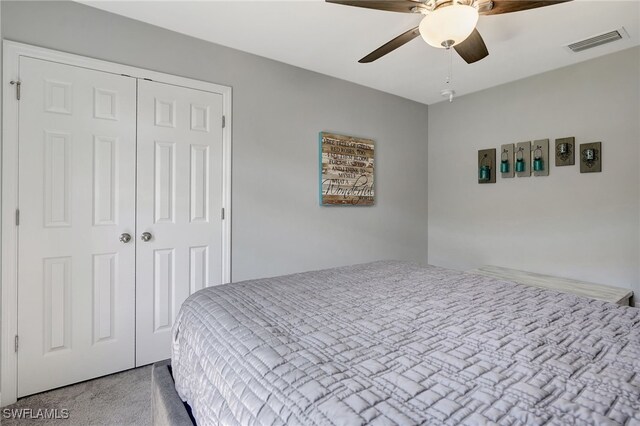 carpeted bedroom with visible vents, a closet, and a ceiling fan