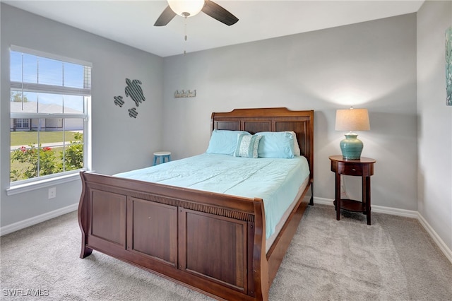 bedroom featuring baseboards, light colored carpet, and a ceiling fan