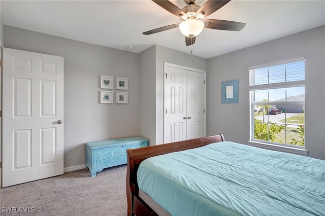 bedroom with a closet, baseboards, carpet, and a ceiling fan