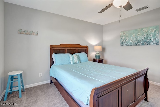 bedroom with visible vents, light colored carpet, baseboards, and ceiling fan