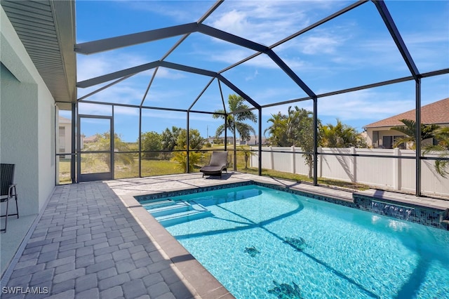 pool featuring glass enclosure and a patio area