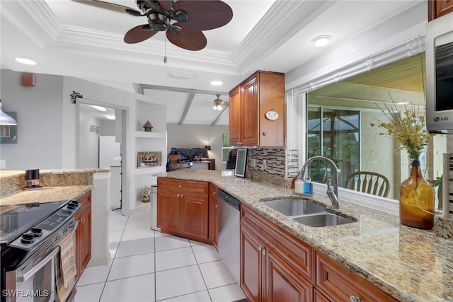 1442 SE 15th Ter, Cape Coral, FL 33990 - kitchen with ceiling fan, stainless steel appliances, a sink, a raised ceiling, and brown cabinetry