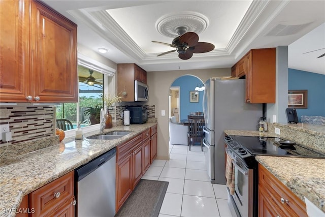1442 SE 15th Ter, Cape Coral, FL 33990 - kitchen featuring appliances with stainless steel finishes, a ceiling fan, a tray ceiling, tasteful backsplash, and crown molding
