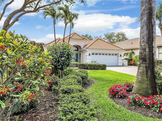 mediterranean / spanish-style home featuring a garage, a tiled roof, decorative driveway, and stucco siding