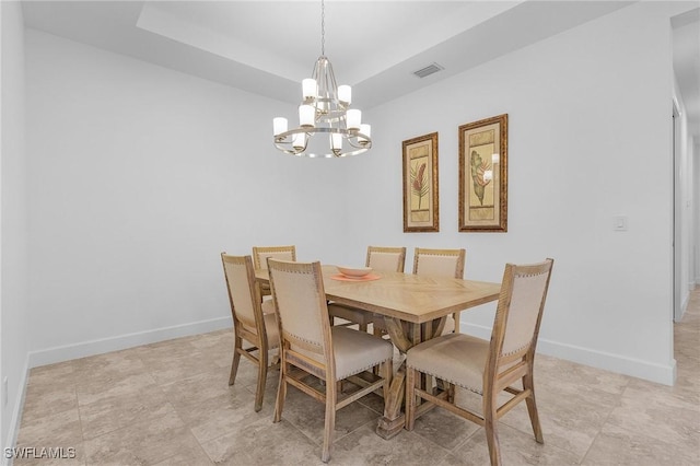 dining area featuring a tray ceiling, a notable chandelier, baseboards, and visible vents