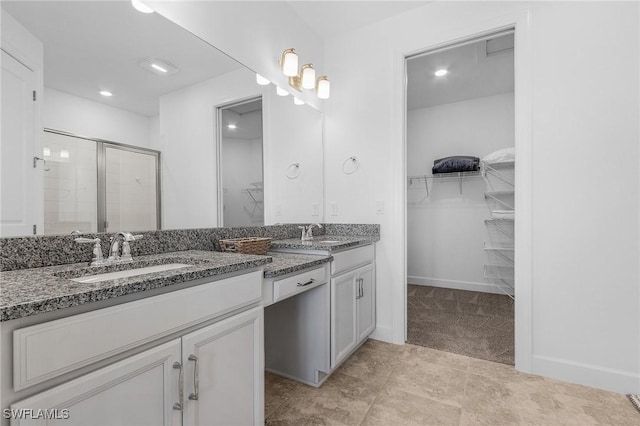 full bath with a walk in closet, baseboards, a stall shower, and vanity