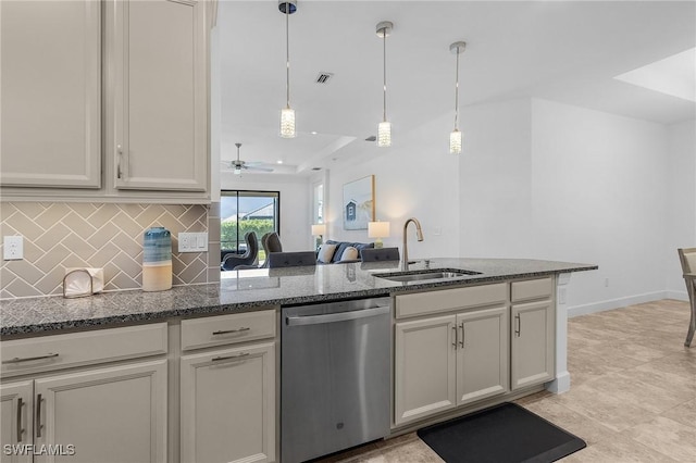 kitchen featuring visible vents, a peninsula, a sink, stainless steel dishwasher, and tasteful backsplash