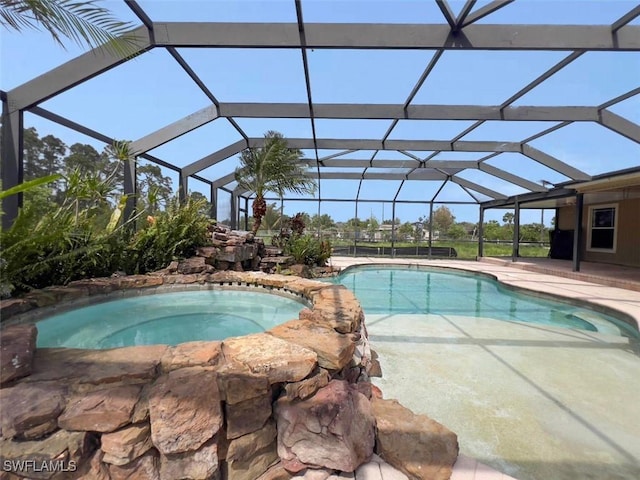 outdoor pool featuring a patio, an in ground hot tub, and a lanai