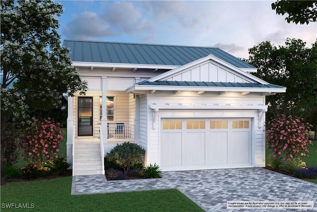 view of front of property featuring a standing seam roof, decorative driveway, and metal roof