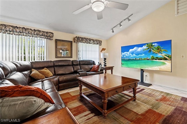 living area featuring light tile patterned floors, a ceiling fan, vaulted ceiling, and a wealth of natural light