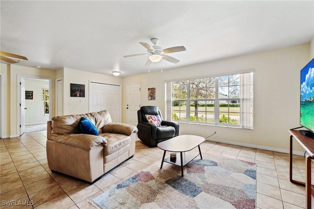 tiled living room with baseboards and a ceiling fan