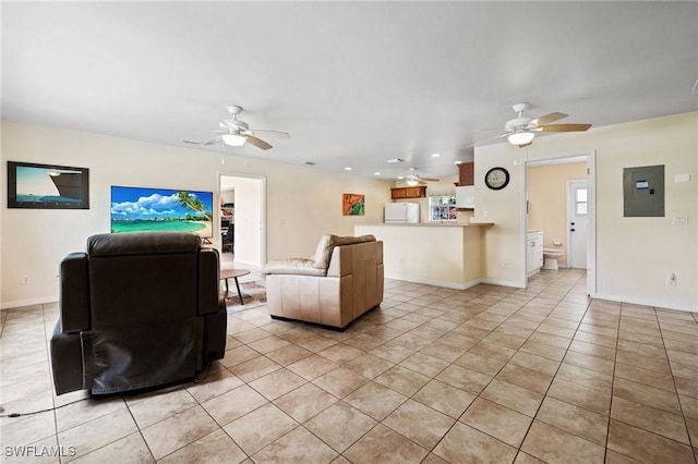 living area with a ceiling fan, electric panel, baseboards, and light tile patterned floors