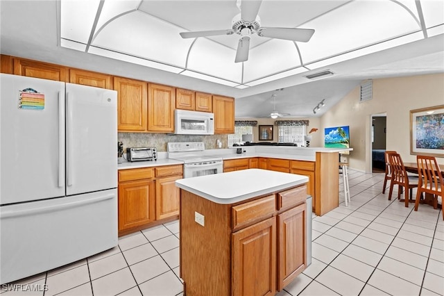 kitchen featuring light tile patterned floors, a peninsula, white appliances, visible vents, and light countertops