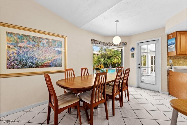 dining space with baseboards and light tile patterned flooring