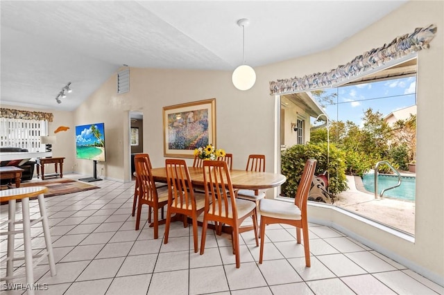 dining area with lofted ceiling and light tile patterned flooring