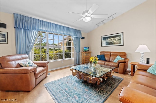 living area featuring a ceiling fan, baseboards, vaulted ceiling, and track lighting