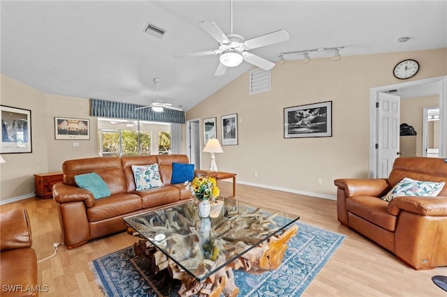 living area featuring visible vents, baseboards, lofted ceiling, light wood-style flooring, and rail lighting