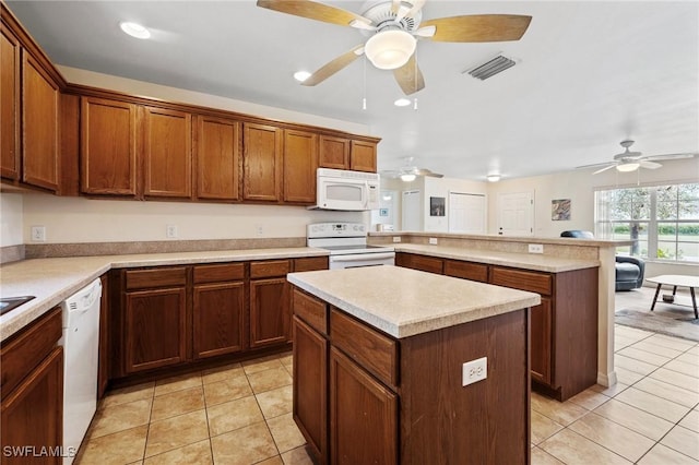 kitchen with white appliances, visible vents, a peninsula, and light tile patterned floors