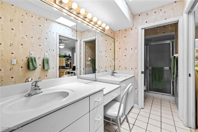 full bath featuring a stall shower, a sink, and wallpapered walls