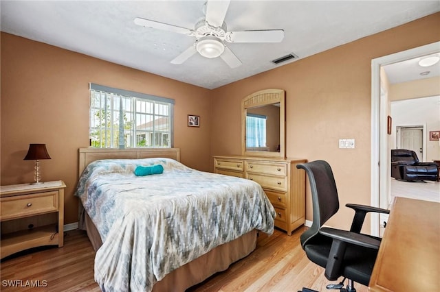 bedroom featuring ceiling fan, baseboards, visible vents, and light wood-style floors