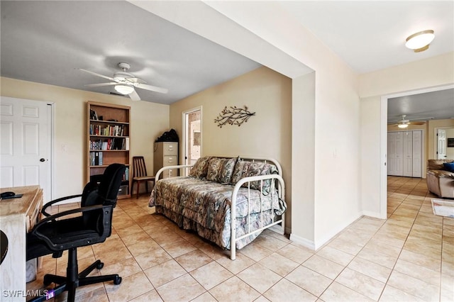 office space featuring light tile patterned floors, built in shelves, a ceiling fan, and baseboards