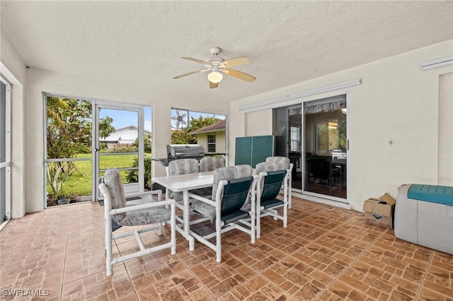 sunroom / solarium featuring a ceiling fan