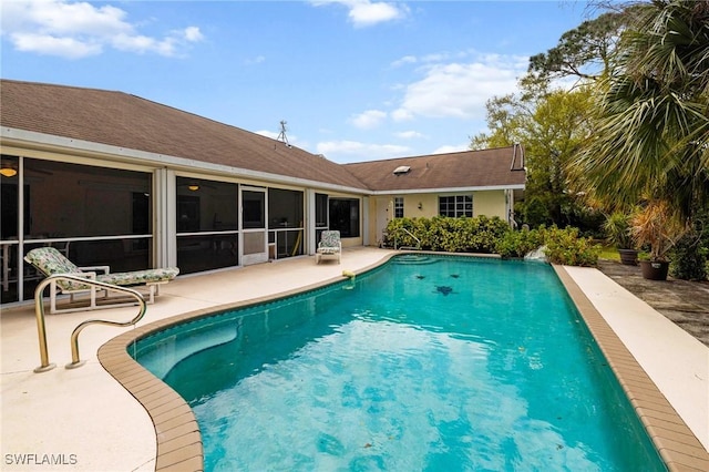 outdoor pool with a sunroom and a patio