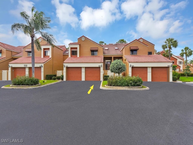 view of front facade with driveway, an attached garage, and stucco siding