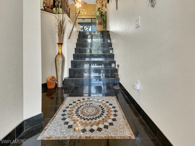 stairs with baseboards and a textured wall