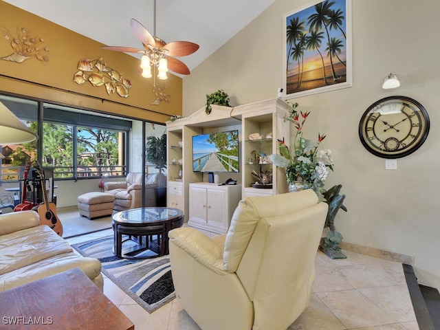 living area with high vaulted ceiling, tile patterned flooring, baseboards, and a ceiling fan