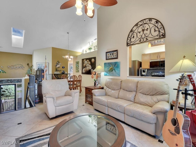 living area featuring ceiling fan with notable chandelier, light tile patterned flooring, and a towering ceiling