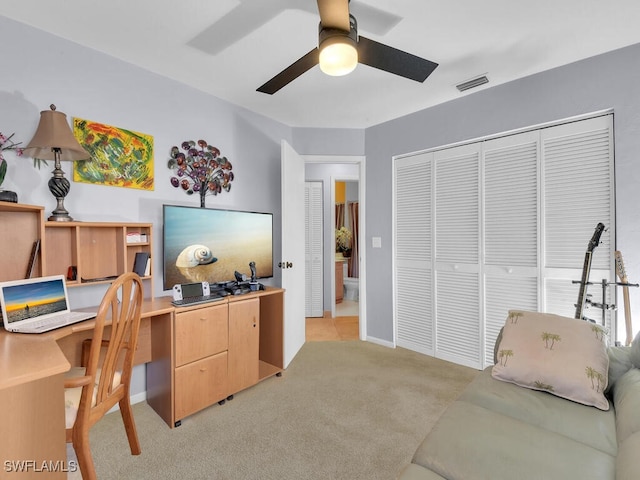 office with light colored carpet, ceiling fan, visible vents, and baseboards