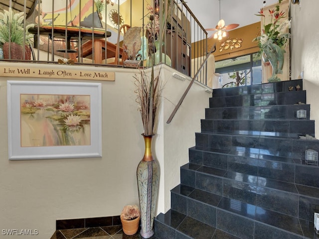 stairs with a ceiling fan and granite finish floor