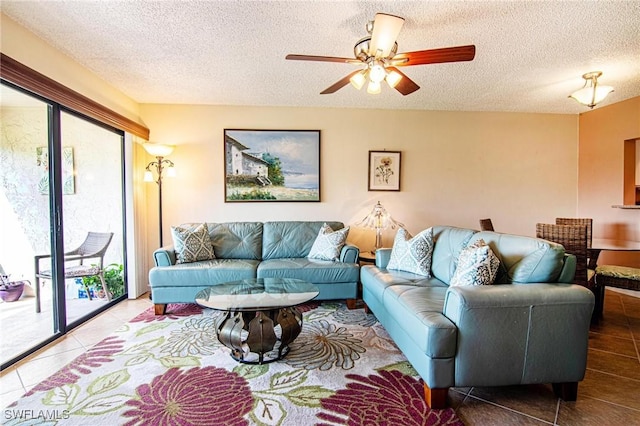 living area featuring a textured ceiling, a ceiling fan, and tile patterned flooring