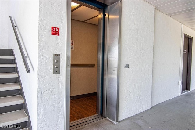 property entrance with stucco siding and elevator