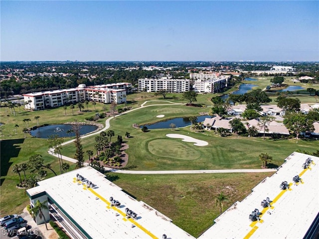 drone / aerial view featuring golf course view and a water view