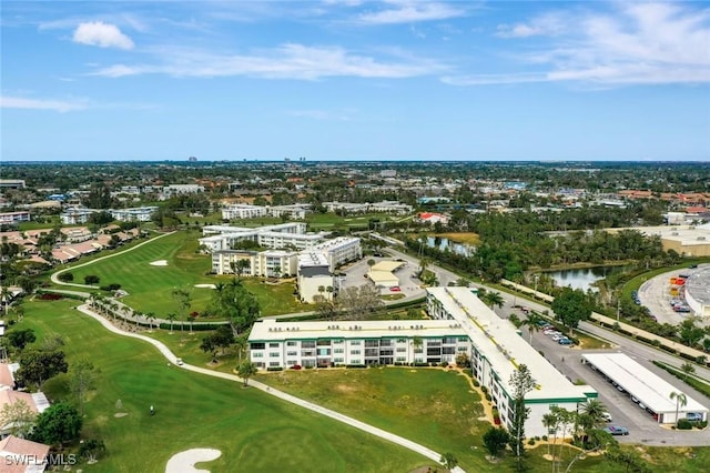 aerial view featuring golf course view, a view of city, and a water view