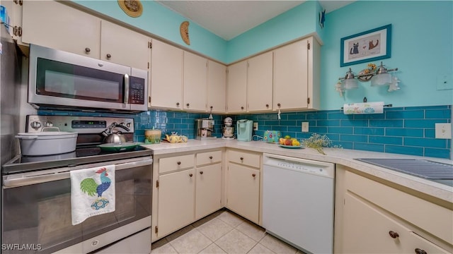 kitchen featuring backsplash, appliances with stainless steel finishes, light tile patterned flooring, and light countertops